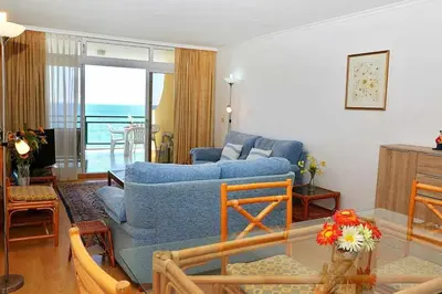 a living room with a blue couch and a table at Formosa Sunset - Em frente à praia com wifi in Panasqueira