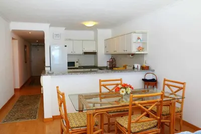 a kitchen and dining room with a table and chairs at Formosa Sunset - Em frente à praia com wifi in Panasqueira