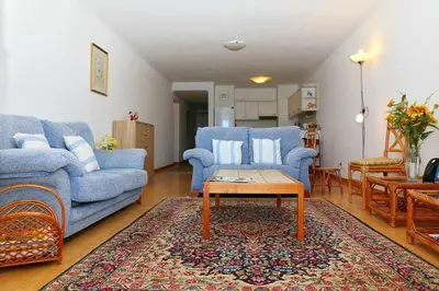 a living room with two blue couches and a coffee table at Formosa Sunset - Em frente à praia com wifi in Panasqueira