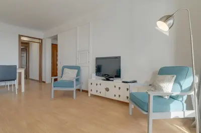 a living room with two blue chairs and a tv at Bahia Top Floor in Funchal
