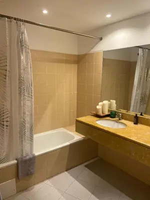 a bathroom with a sink and a tub and a mirror at Rocha Mar 3M in Ribeira Brava