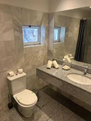 a bathroom with a toilet and a sink and a mirror at Rocha Mar 3M in Ribeira Brava