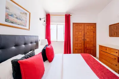 a bedroom with a large bed with red curtains at Monte Sao Pedro - Villa in Luz