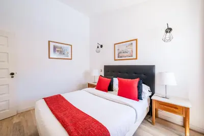 a bedroom with a large bed with red pillows at Monte Sao Pedro - Villa in Luz