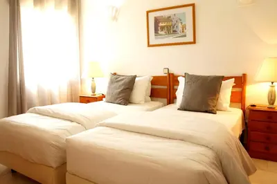 two beds in a hotel room with white sheets at Monte Sao Pedro - Villa in Luz