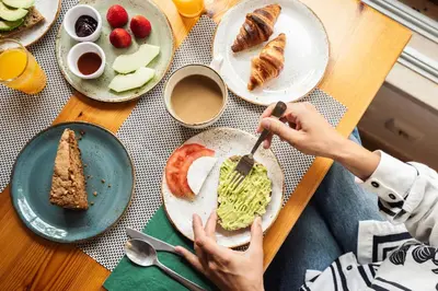 a person eating food on a table with plates of food at Monte Da Vilarinha in Carrapateira