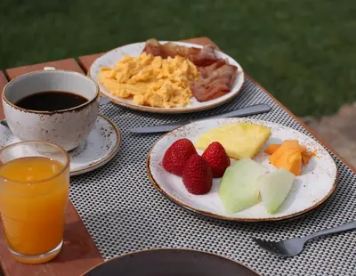 two plates of fruit and a cup of coffee on a table at Monte Da Vilarinha in Carrapateira