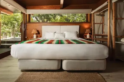 a bedroom with a white bed with a large window at Monte Da Vilarinha in Carrapateira