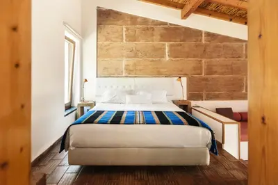 a bedroom with a bed and a brick wall at Monte Da Vilarinha in Carrapateira