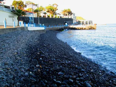 a rocky beach next to a body of water at Albergaria O Professor in Santa Cruz
