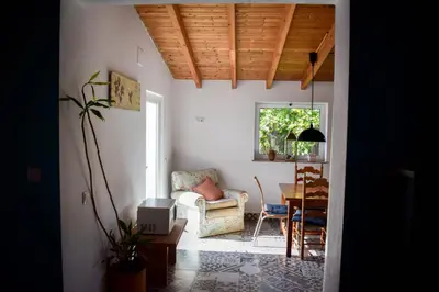 a living room with a chair and a table at Casinhas da Figueira in Budens
