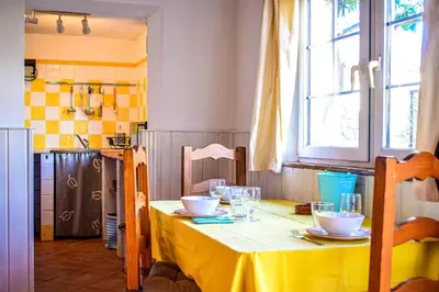 a kitchen with a table with a yellow table cloth at Casinhas da Figueira in Budens