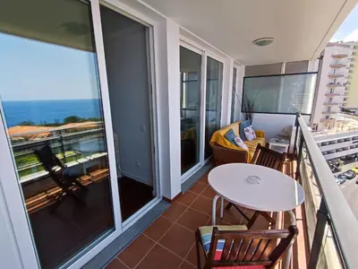 a balcony with a table and chairs and a table at The Lidosol - Phenomenal view over the Atlantic Ocean in Funchal