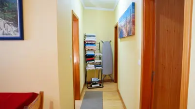 a hallway with a room with a door and a pile of towels at Apartamento Barros in Estreito de Câmara de Lobos