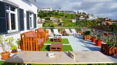 a patio with chairs and tables on a balcony at Apartamento Barros in Estreito de Câmara de Lobos