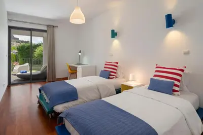 a bedroom with two beds and a balcony at Piscina fantástica no centro da cidade! in Funchal