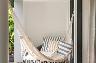 a hammock on a porch with pillows at Piscina fantástica no centro da cidade! in Funchal