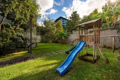 a playground with a slide in a yard at Piscina fantástica no centro da cidade! in Funchal