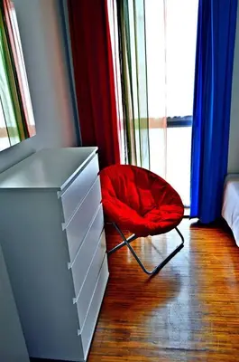 a red chair sitting next to a dresser in a room at vista dos arrifes in Funchal