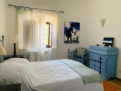 a bedroom with a bed and a blue dresser at Dona Maria 66 in Luz