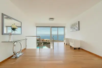 a white room with a dining room with a view of the ocean at Villa Panoramica II in Arco da Calheta