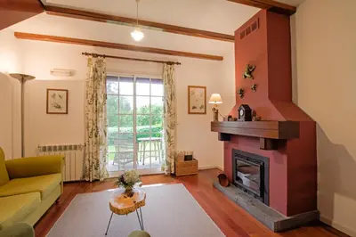a living room with a fireplace and a couch at Quinta Santo Antonio Da Serra in Santa Cruz