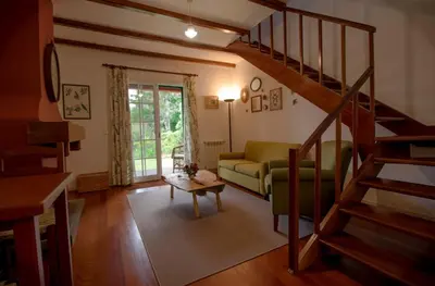 a living room with a couch and a staircase at Quinta Santo Antonio Da Serra in Santa Cruz