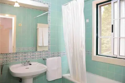 a blue bathroom with a sink and a mirror at Quinta Santo Antonio Da Serra in Santa Cruz