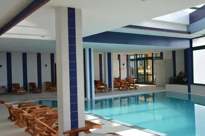 a pool in a building with chairs and tables at Hotel Jardim Atlantico in Calheta