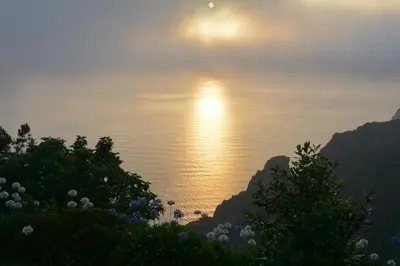 a view of the ocean with the sun in the sky at Hotel Jardim Atlantico in Calheta
