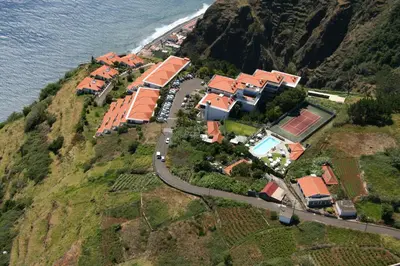 a group of houses on a hill next to the ocean at Hotel Jardim Atlantico in Calheta