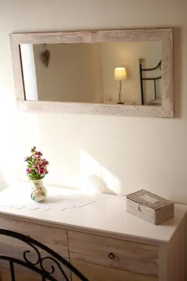 a mirror on top of a dresser with a plant on it at Casa da Rainha Bungallow in Estreito da Calheta