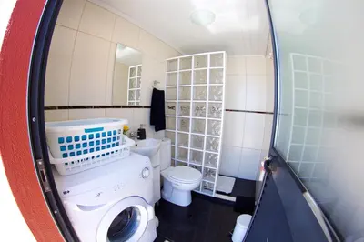 a bathroom with a washing machine and a toilet at Casa da Rainha Bungallow in Estreito da Calheta