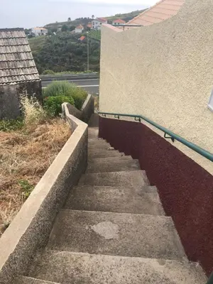 a set of concrete stairs next to a building at Casa da Rainha Bungallow in Estreito da Calheta