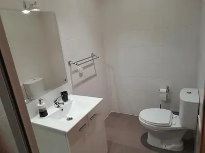 a white bathroom with a toilet and a sink at Sweet Home for Holidays in Machico