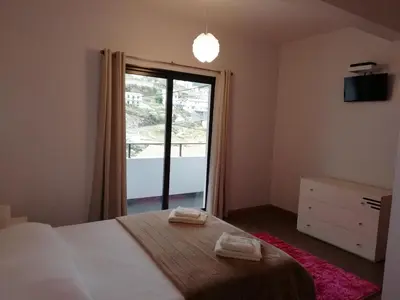 a bedroom with a bed and a large window at Sweet Home for Holidays in Machico