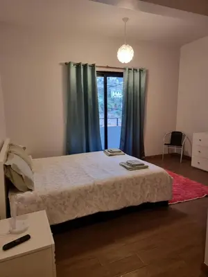 a bedroom with a bed with blue curtains and a window at Sweet Home for Holidays in Machico