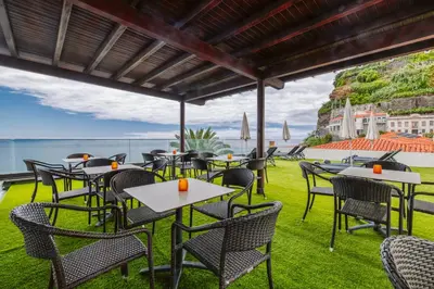 a restaurant with a view of the ocean at Enotel Sunset Bay in Ponta do Sol
