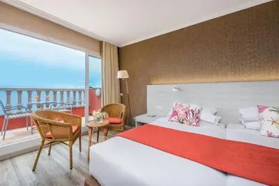 a hotel room with a bed and a balcony at Enotel Sunset Bay in Ponta do Sol