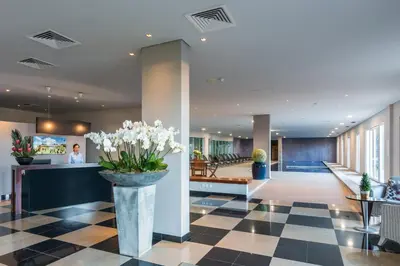 a lobby with a vase of flowers on a checkered floor at Enotel Sunset Bay in Ponta do Sol