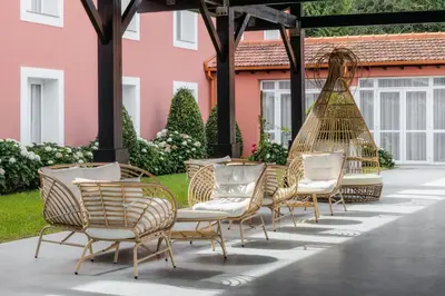 a group of chairs and a hammock outside a building at Enotel Santo da Serra in Santo da Serra