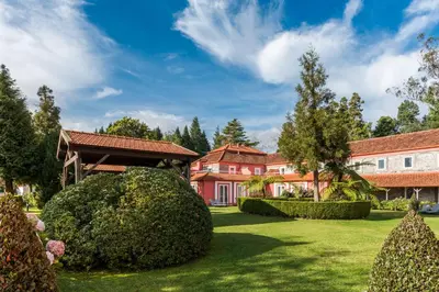a house with a yard with bushes and trees at Enotel Santo da Serra in Santo da Serra