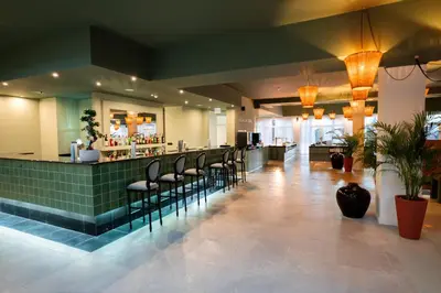 a restaurant with a bar with chairs and a counter at Enotel Santo da Serra in Santo da Serra