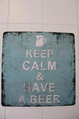 a sign that says keep calm and have a beer at Refugio Madeira in Caniço