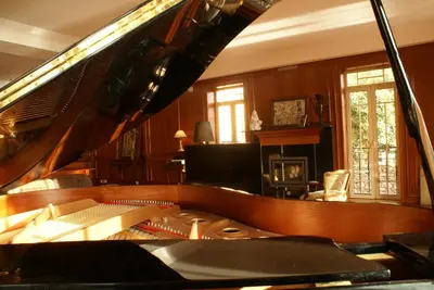 a living room with a grand piano and a living room with at Quinta Paços do Lago in Funchal