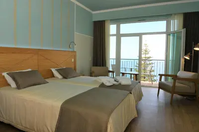 a hotel room with a large bed and a balcony at Hotel Do Campo in Ribeira Brava