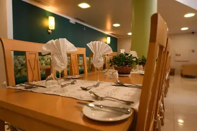a table with plates and silverware on top at Hotel Do Campo in Ribeira Brava
