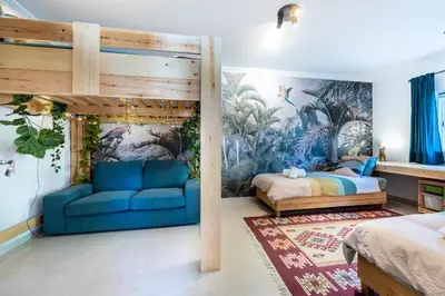 a bedroom with a bed and a blue couch at Casa Skip in Aljezur