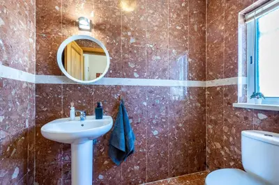 a bathroom with a sink and a mirror and a toilet at Casa Skip in Aljezur