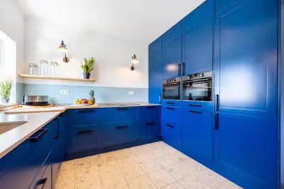a blue kitchen with white counters and blue cabinets at Casa Skip in Aljezur